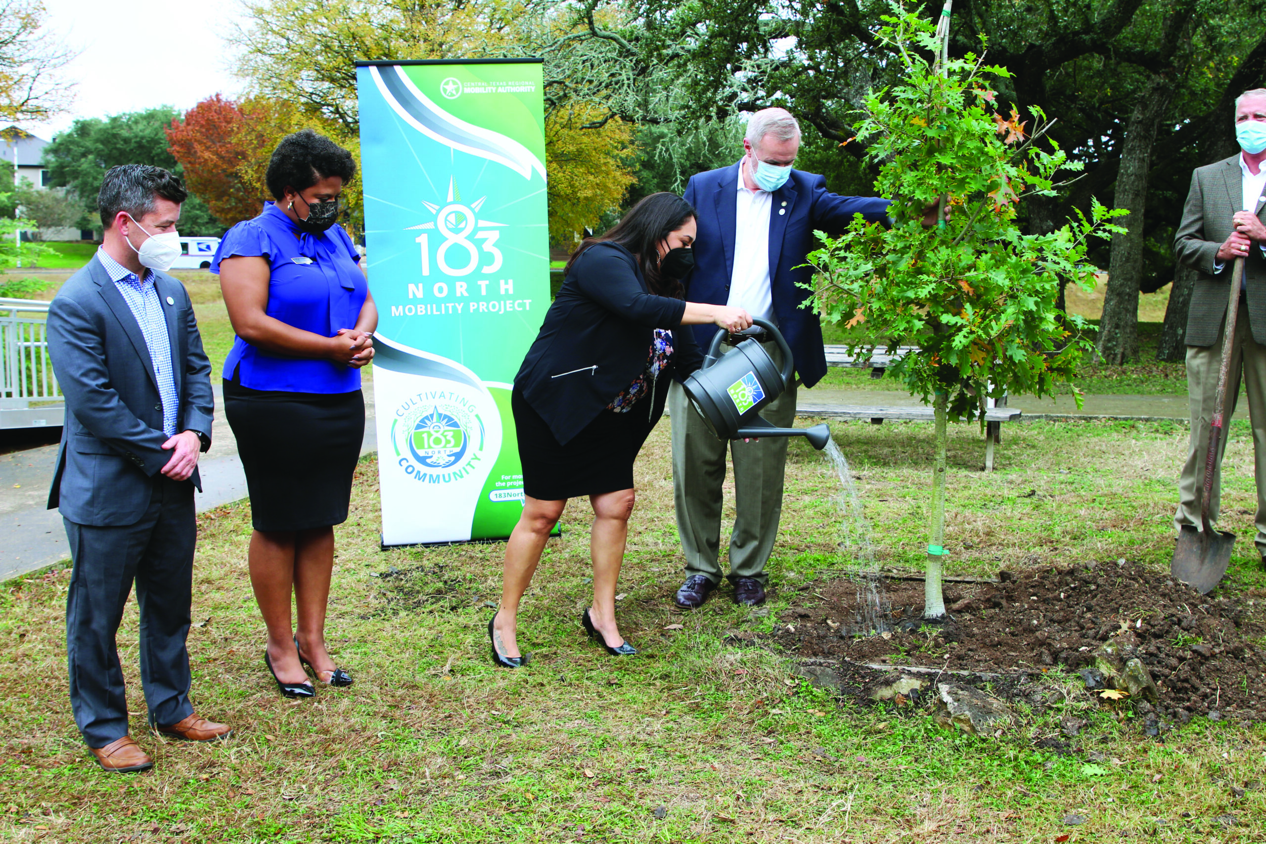 Board members participating in the tree watering ceremony