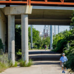 Man walking on the MoPac Trail under and overpass