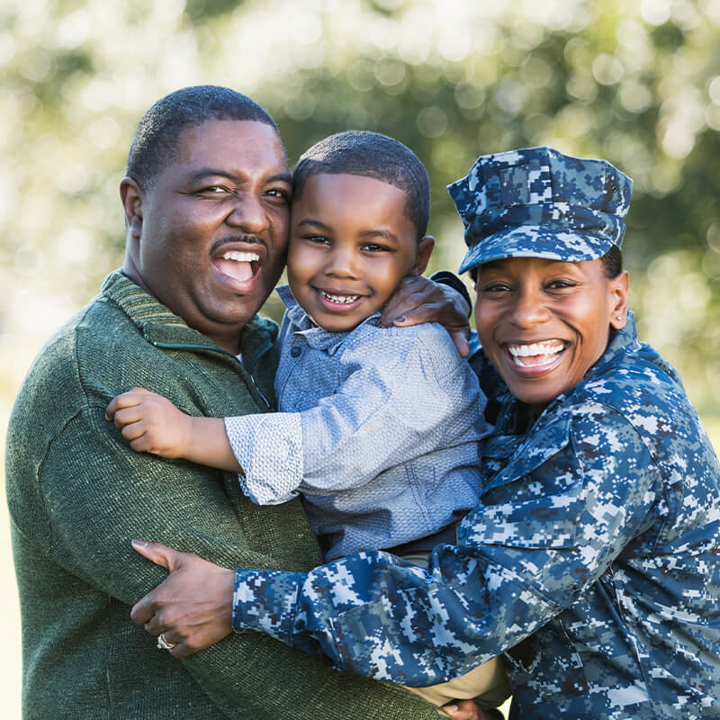 A smiling veteran posing with her family